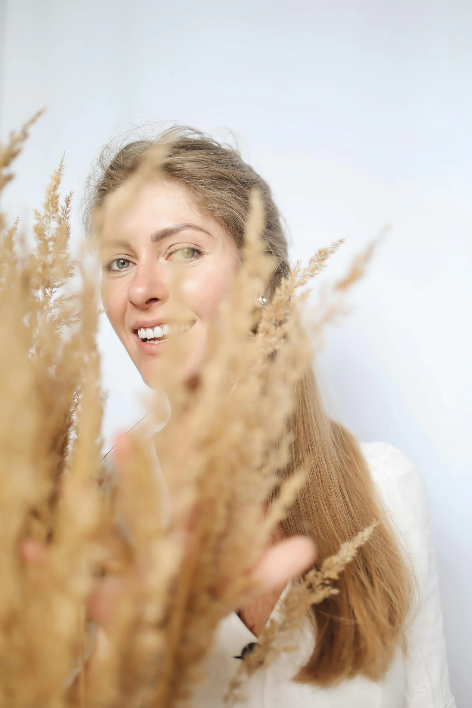 a woman holding a bunch of dry grass in front of her face, by Julia Pishtar, renaissance, looking happy, profile image, angelina stroganova, multiple stories