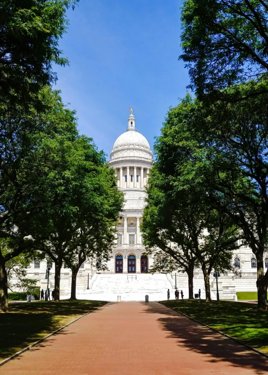 a large white building surrounded by trees on a sunny day, neoclassicism, rhode island, with great domes and arches, slide show, square
