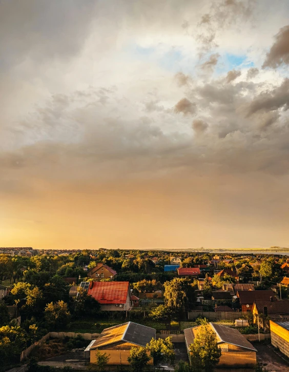 a view of a city from the top of a building, rainbow colored clouds, in a suburb, golden hour photograph, suburb