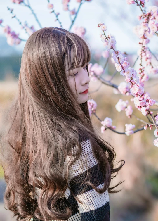 a woman standing in front of a flowering tree, inspired by Ma Yuanyu, unsplash, brown long hair with bangs, beauty filter, avatar image, ulzzang