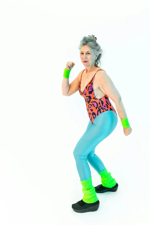 a woman standing on top of a skateboard on a white surface, by Pamela Drew, happening, in spandex suit, elderly, dayglo, doing a sassy pose