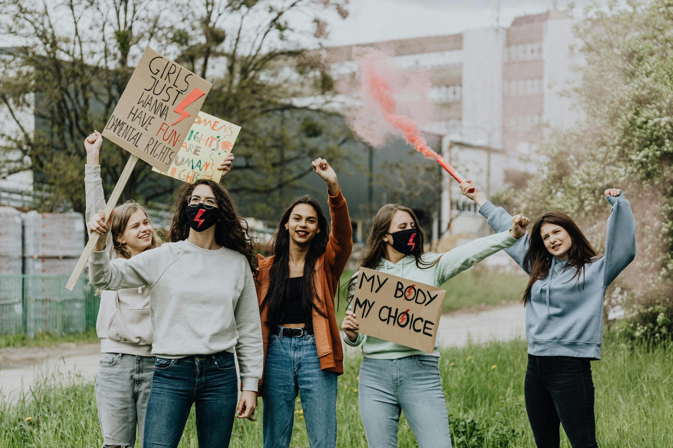 a group of women standing next to each other holding signs, trending on pexels, teenager girl, grassy knoll, avatar image, smoke grenades