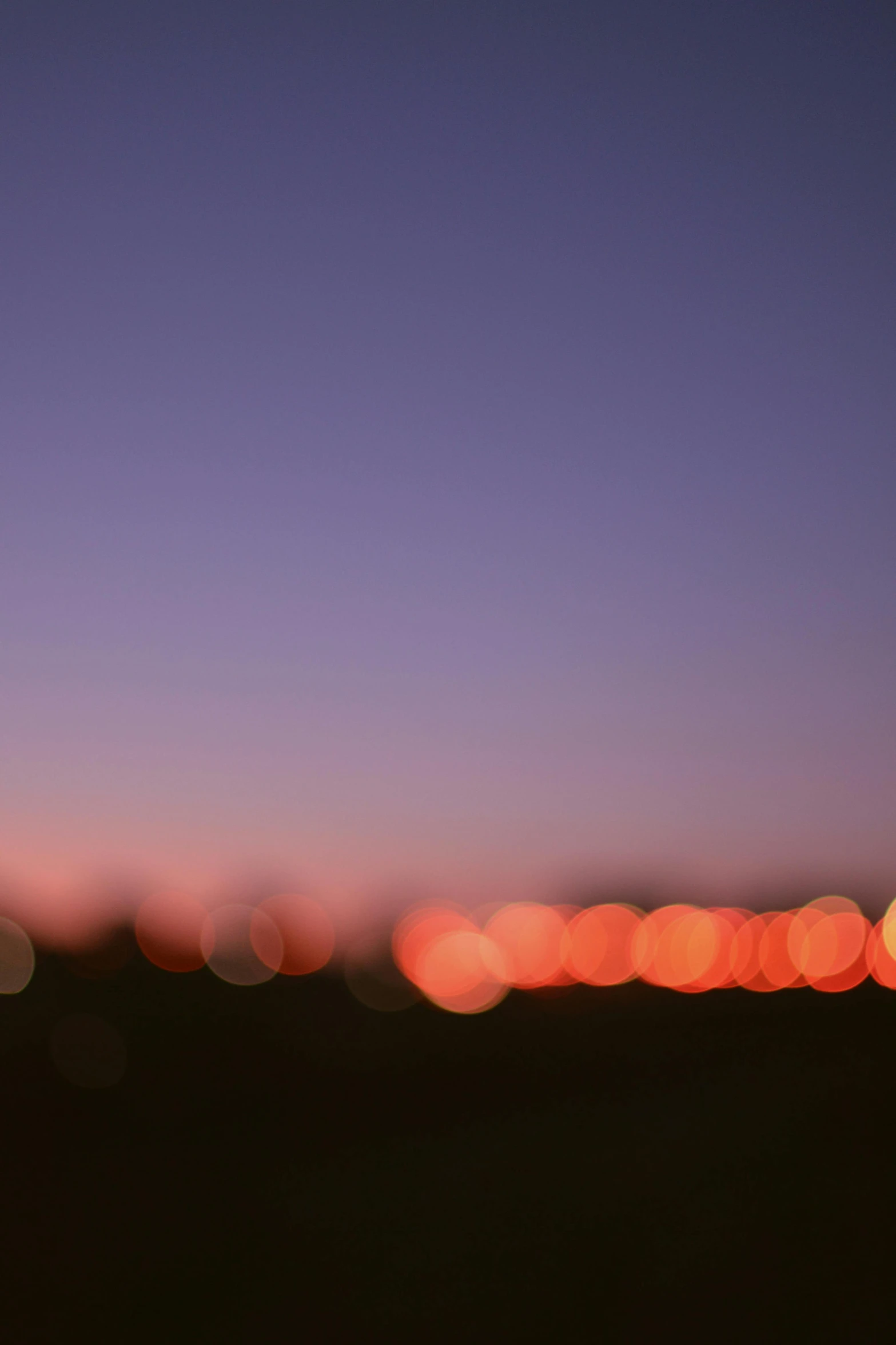 a blurry photo of a city at night, a picture, by David Donaldson, minimalism, sunset sky, hasselblad film bokeh, purple and red, bokeh. i