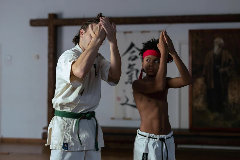 a couple of men standing next to each other in a room, inspired by Baiōken Eishun, pexels contest winner, fist training, samurai with afro, white bandages on fists, daniel richter