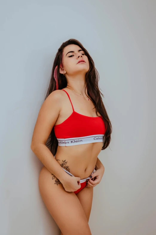 a woman in a red bikini posing for a picture, inspired by Elsa Bleda, instagram, bra and shorts streetwear, profile image, colombian, calvin klein photograph