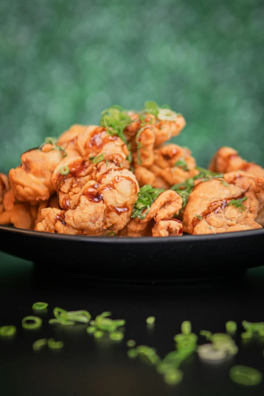 a close up of a plate of food on a table, fried chicken, with a black background, celtics, thumbnail