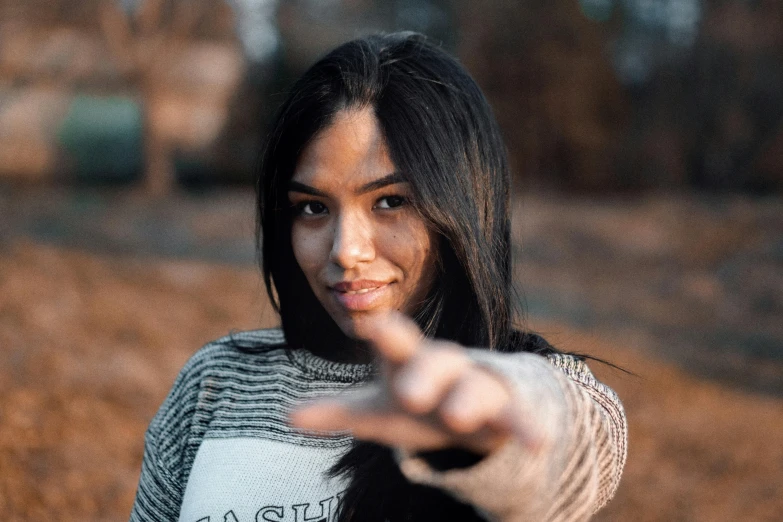 a woman pointing her finger at the camera, trending on pexels, tachisme, with straight black hair, pose 4 of 1 6, brown, slightly pixelated