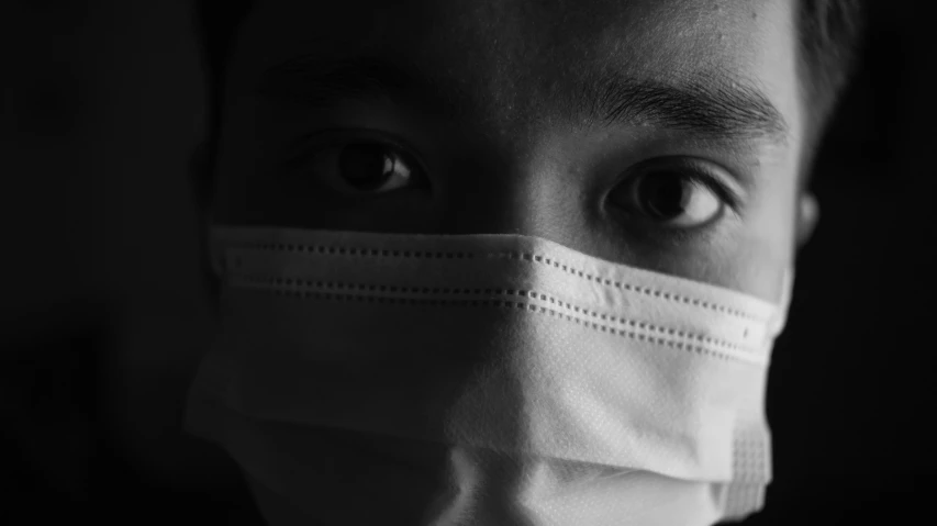 a close up of a person wearing a face mask, a black and white photo, pexels, detailed face of a asian boy, healthcare worker, inside an dystopian, coronavirus