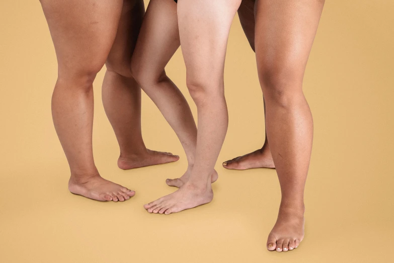 a group of women standing next to each other, inspired by Vanessa Beecroft, trending on pexels, incoherents, detailed shot legs-up, gradient brown to white, three hairy neanderthal people, plain background