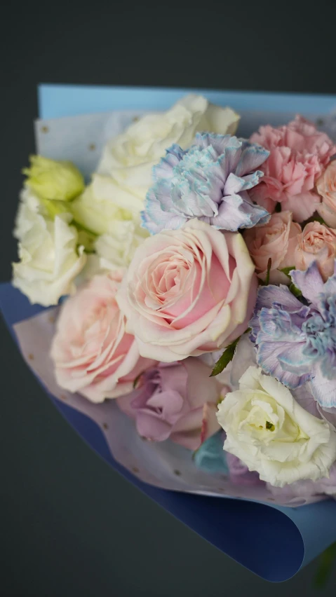 a close up of a bouquet of flowers, pastel blues and pinks, on a gray background, cotton candy, roses