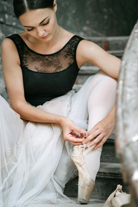 a ballerina tying up her ballet shoes, trending on pexels, arabesque, wearing a formal dress, pondering, black, delicate embellishments