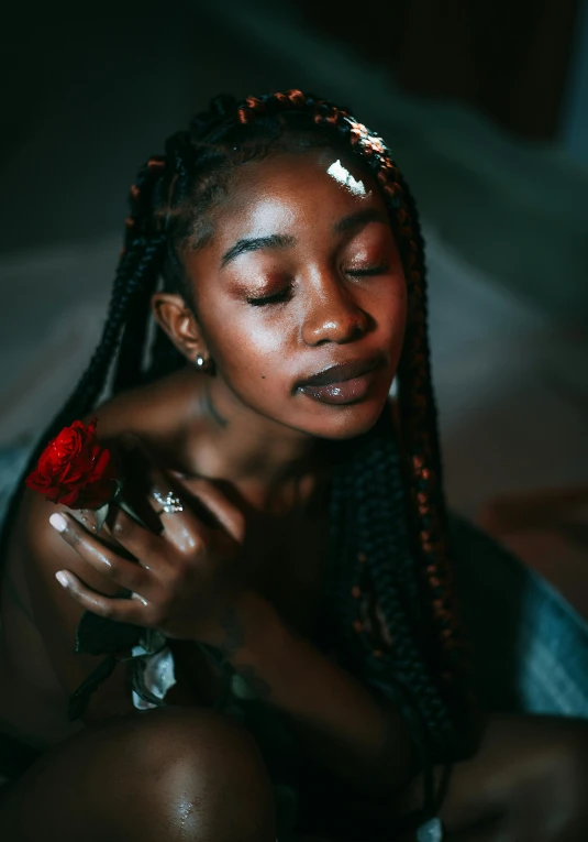 a woman sitting on a bed with her eyes closed, by Adam Marczyński, trending on pexels, black arts movement, braided hair with roses, ☁🌪🌙👩🏾, young woman's face, intimately holding close