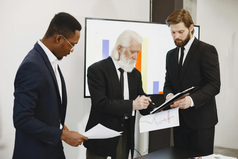 a group of men standing around a table with papers, by Gavin Hamilton, pexels contest winner, analytical art, corporate holograms, white hair and white beard, whiteboards, ignant