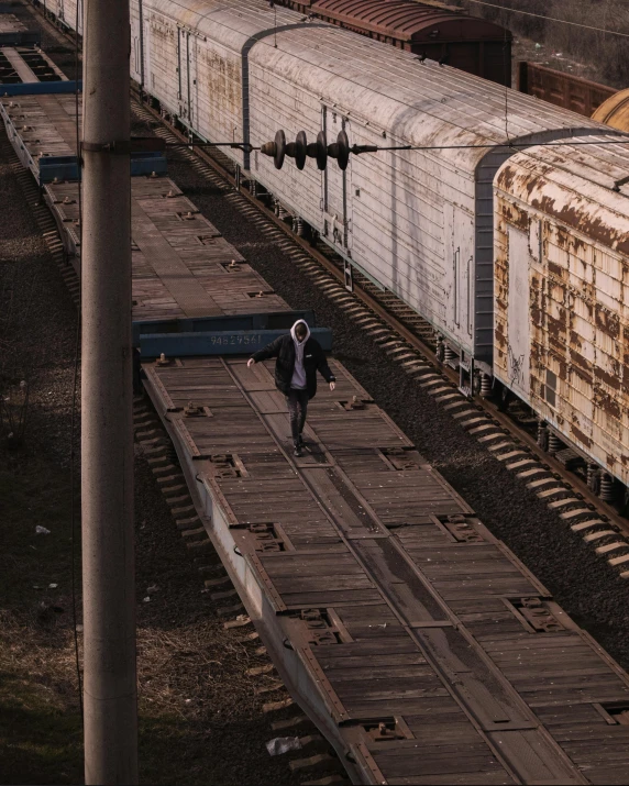 a large long train on a steel track, an album cover, pexels contest winner, non-binary, shipping containers, hes alone, about to step on you