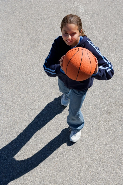 a young girl holding a basketball in a parking lot, inspired by Mia Brownell, dribble contest winner, [ overhead view ]!, high shadow, no cropping, single subject