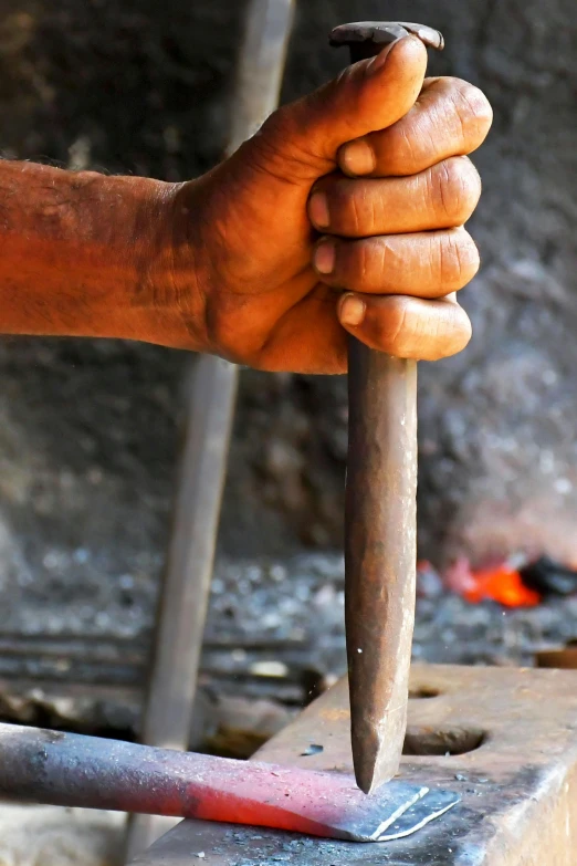 a close up of a person holding a hammer, by Arthur Sarkissian, iron smelting pits, sleek hands, sasai ukon masanao, profile pic