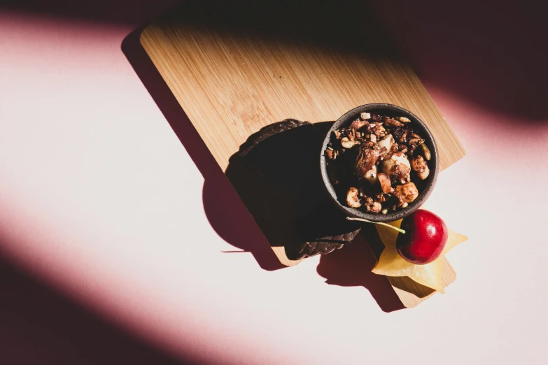 a bowl of cereal and a cherry on a cutting board, by Julia Pishtar, renaissance, chocolate, pink, thumbnail, product shot