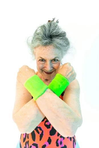 an older woman holding a tennis racquet in one hand and a tennis racquet in the other, an album cover, by Helen Stevenson, happening, neon hand sports bracelet, green body, crossed arms, elderly