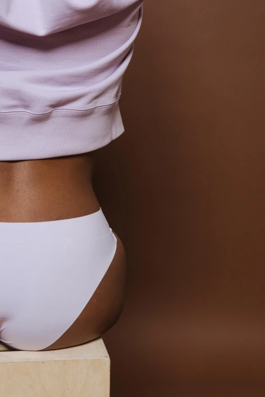 a woman sitting on top of a wooden block, trending on unsplash, cute panties, gradient brown to white, curved. studio lighting, physical : tinyest midriff ever