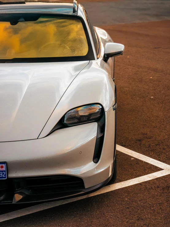 a white sports car parked in a parking lot, inspired by Harry Haenigsen, unsplash, renaissance, square nose, low quality photo, electric, medium closeup