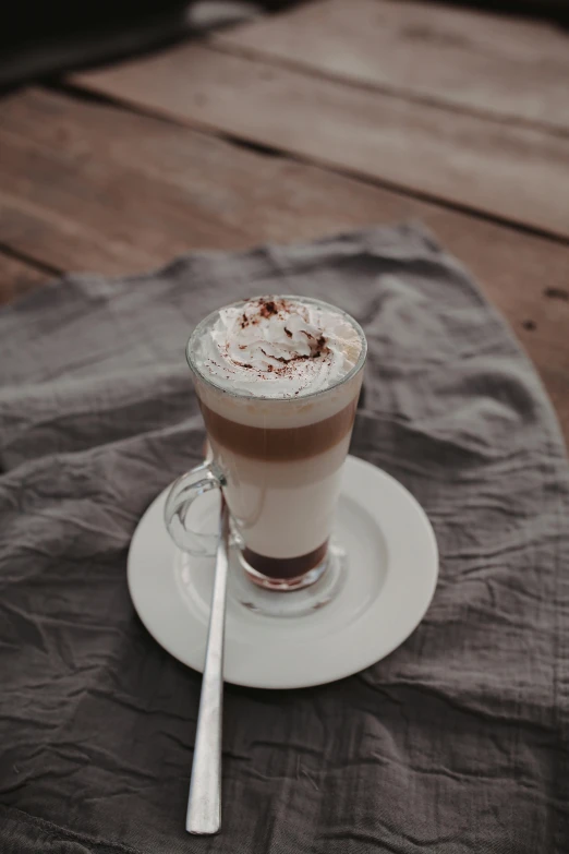 a close up of a cup of coffee on a table, beige mist, whipped cream, best selling, multiple stories
