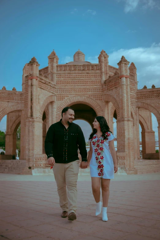 a man and woman walking in front of a castle, curving geometric arches, photo session, mexican, 2019 trending photo