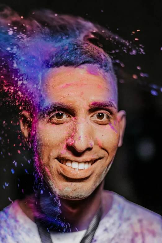 a man with blue and purple powder on his head, a colorized photo, inspired by Ismail Gulgee, pexels contest winner, happily smiling at the camera, splattered goo, vinny from vinesauce, spotlight in middle of face