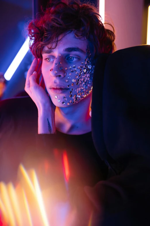 a woman with glitter on her face in front of a mirror, an album cover, trending on pexels, attractive man, glowing lights!! sci - fi, teenage boy, covered in circuitry