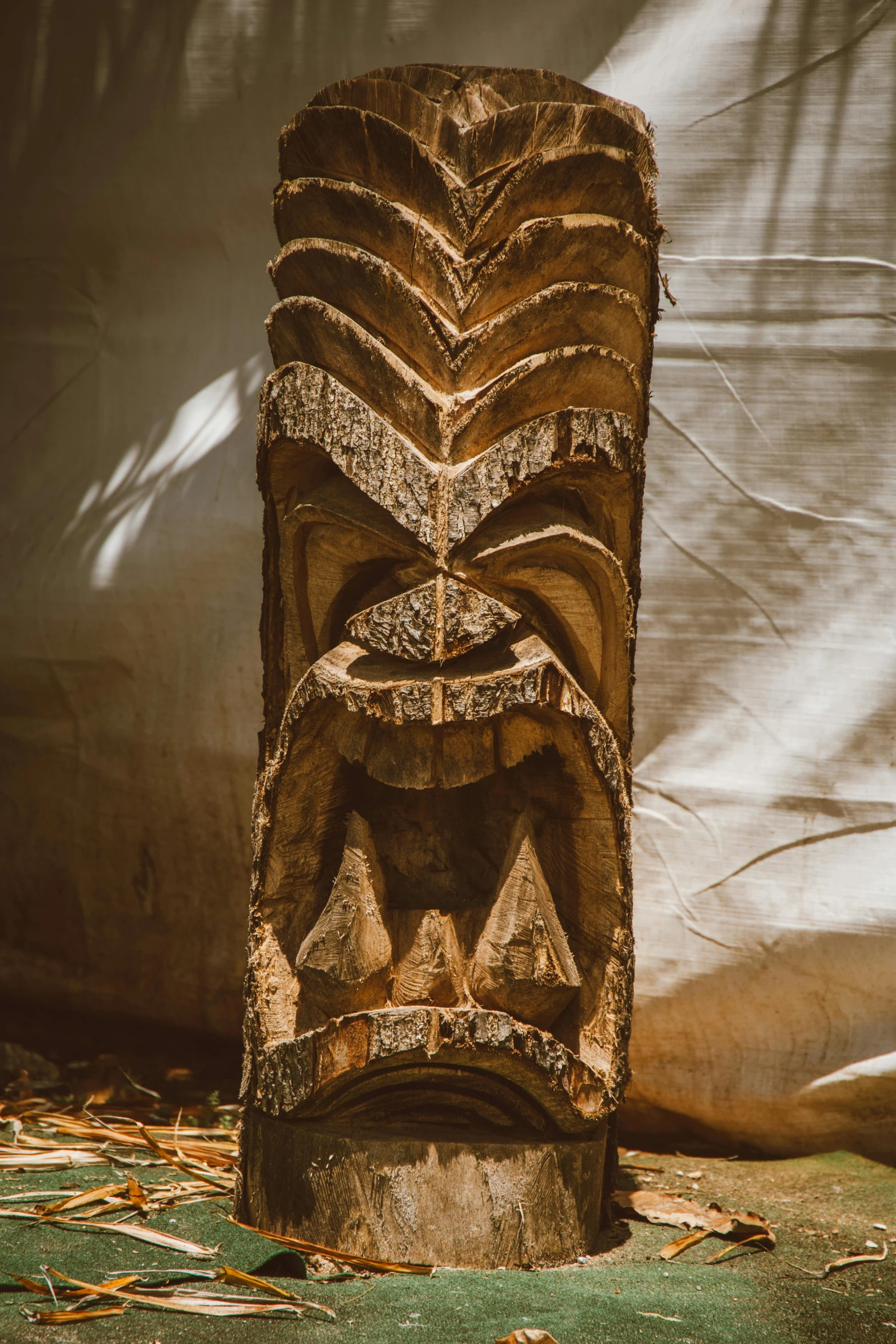 a close up of a wooden statue on the ground, wall art, samoan features, gnarly details soft light, hut