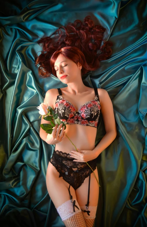 a woman laying on a bed with a rose in her hand, a portrait, inspired by Konstantin Somov, pixabay contest winner, barbie doll in panties and bra, cute young redhead girl, full body close-up shot, silk