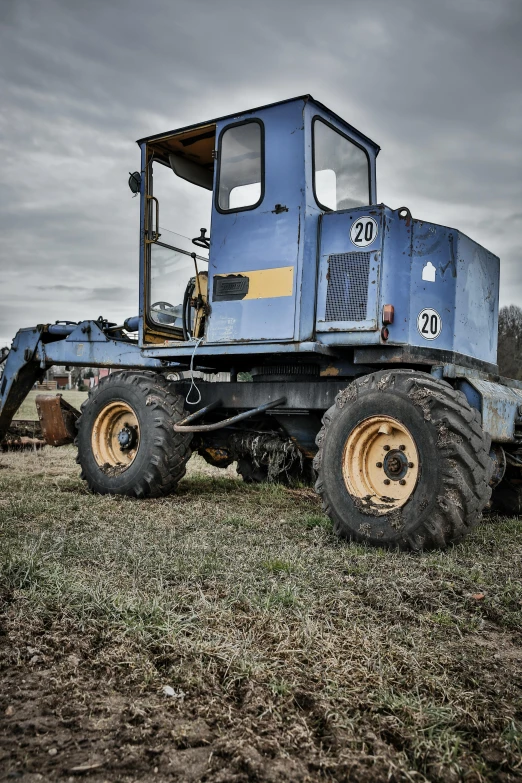 a blue tractor is parked in a field, construction equipment 1 9 9 0, 2022 photograph, square jaw, greatly detailed