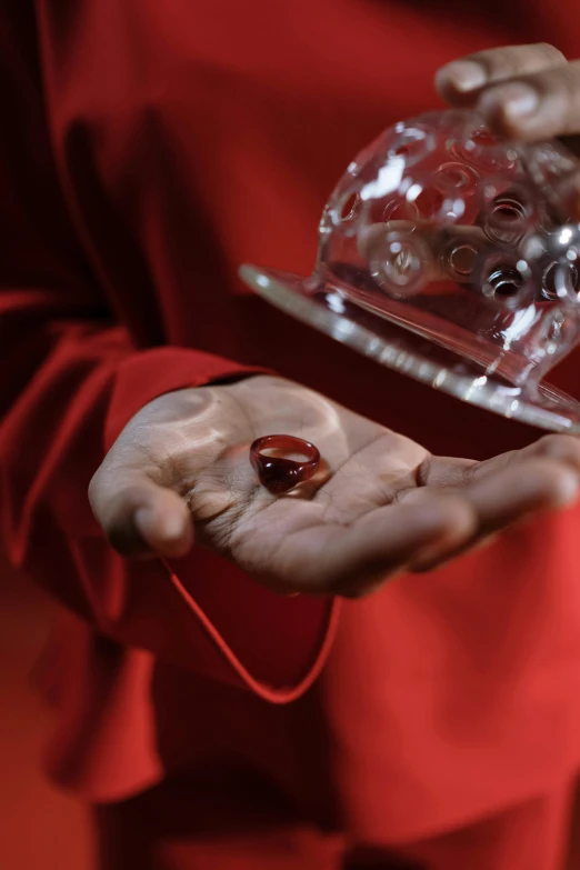 a close up of a person holding something in their hands, red liquid, presenting magic gem, award-winning shot, nanquan