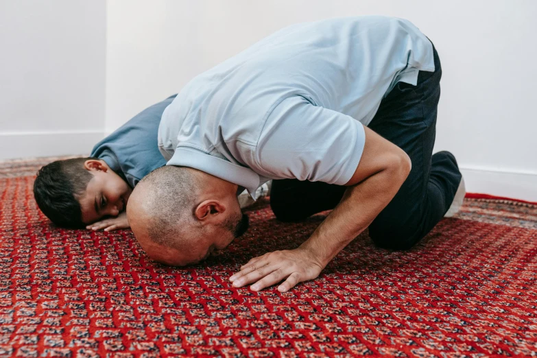 a man kneeling on top of a red rug, by Dan Content, pexels contest winner, hurufiyya, bent over posture, muslim, eyes closed, caretaker