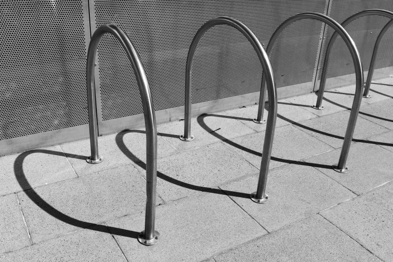 a black and white photo of a row of bike racks, smooth curvatures, a pair of ribbed, instagram photo, stainless steel