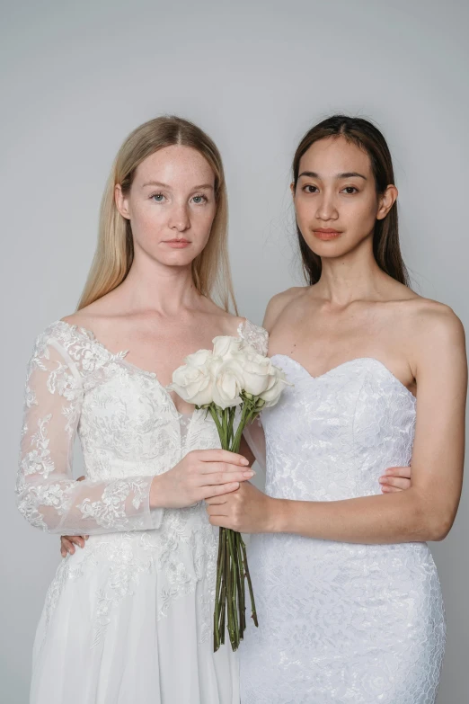 two women standing next to each other holding flowers, by Robbie Trevino, white regal gown, promo image, fair skinned, olivia kemp