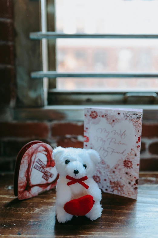 a white teddy bear sitting on top of a wooden table, various items, crimson themed, indoor picture, boston