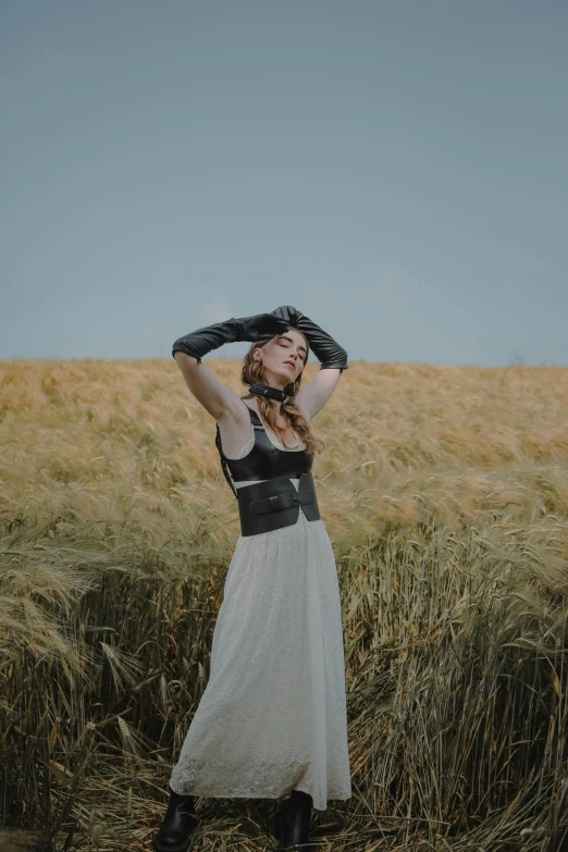 a woman standing in a field of tall grass, unsplash contest winner, renaissance, leather clothing, posing on wheat field, slightly minimal, waving