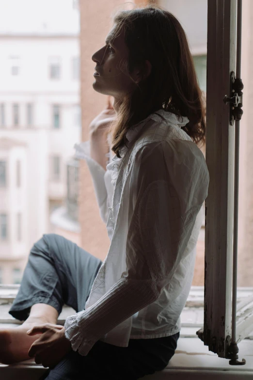 a woman sitting on a window sill looking out a window, inspired by Elsa Bleda, trending on unsplash, renaissance, young handsome man, mid long hair, clothed in white shirt, thoughtful )