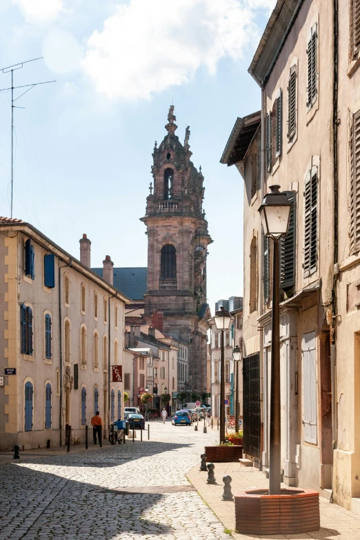 a cobblestone street with a clock tower in the background, inspired by Pierre Toutain-Dorbec, romanesque, slide show, prefecture streets, overview, lead - covered spire