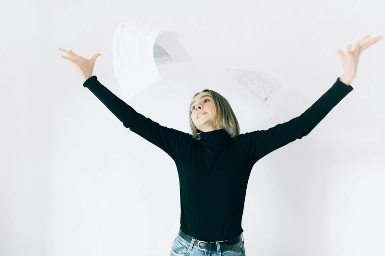 a woman throwing a sheet of paper in the air, an album cover, by Emma Andijewska, pexels contest winner, minimalism, black turtle neck shirt, happy girl, unsplash transparent, sydney sweeney