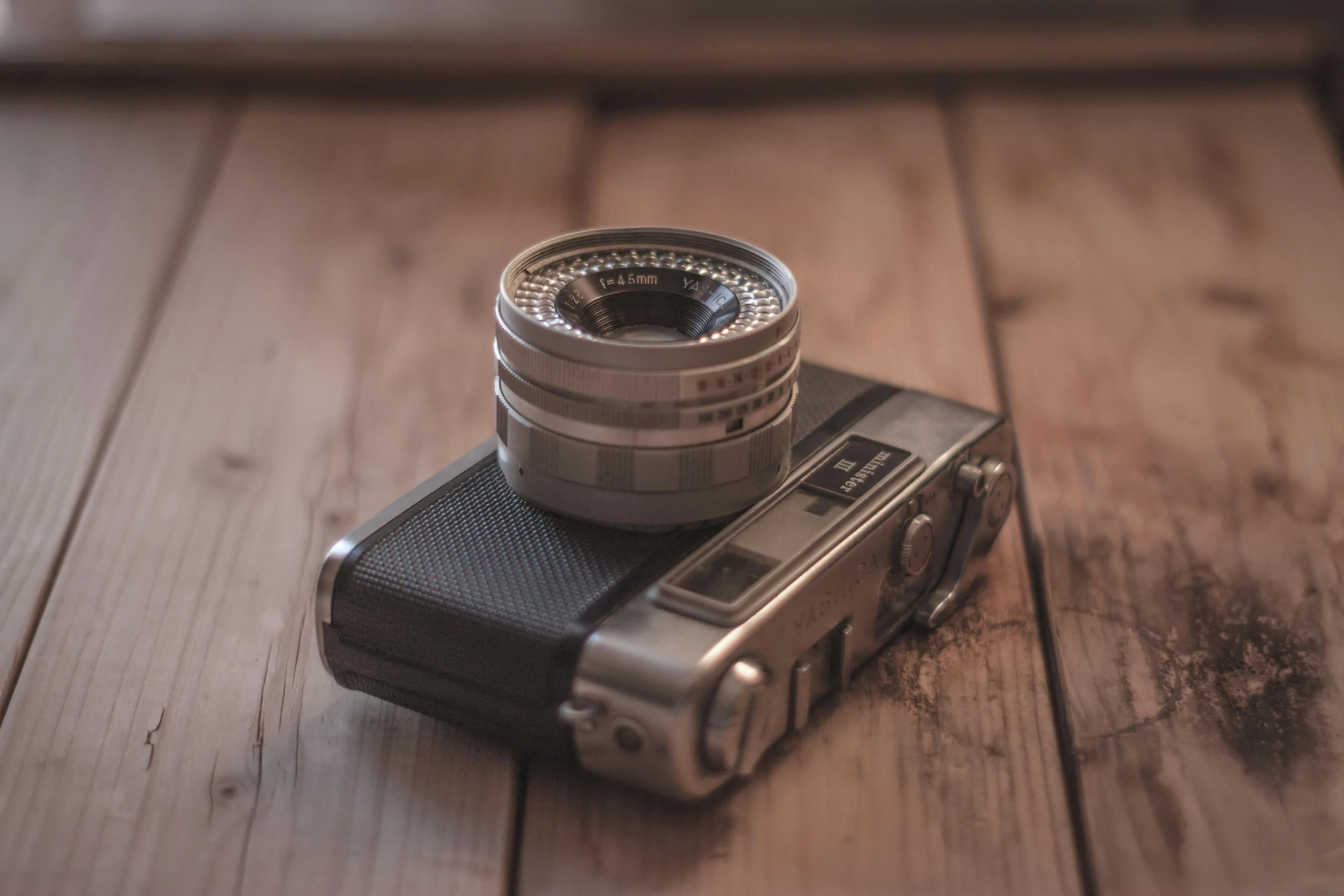 a camera sitting on top of a wooden table, inspired by Henri Cartier-Bresson, unsplash contest winner, medium format. soft light, posing for a picture, rolleiflex, short telephoto