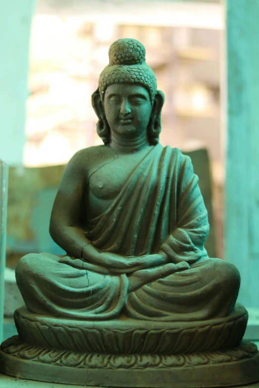 a statue of a buddha sitting on top of a table, on location