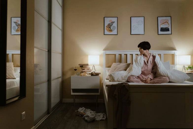 a woman sitting on a bed in a bedroom, by Adam Marczyński, pexels contest winner, south korean male, worried, slightly minimal, in the bedroom at a sleepover