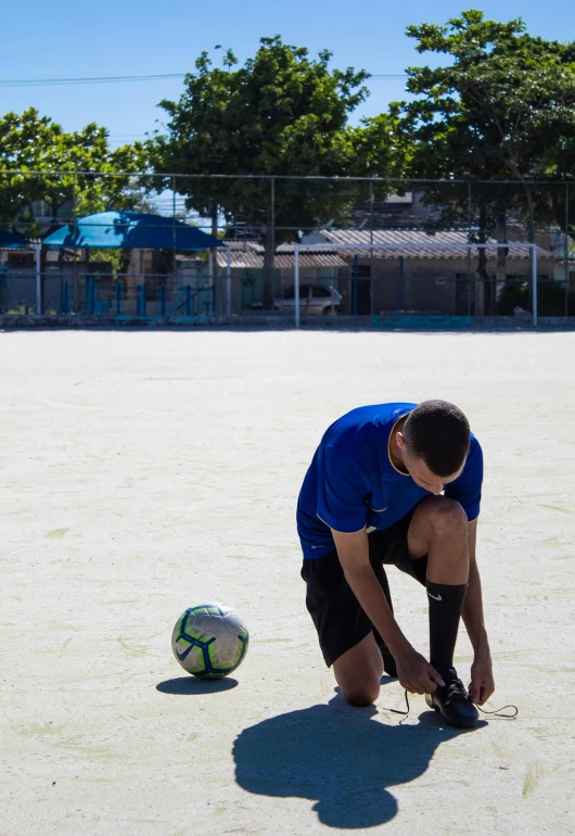 a man bending over to pick up a soccer ball, inspired by david rubín, dribble, on the concrete ground, schools, jc park, profile image