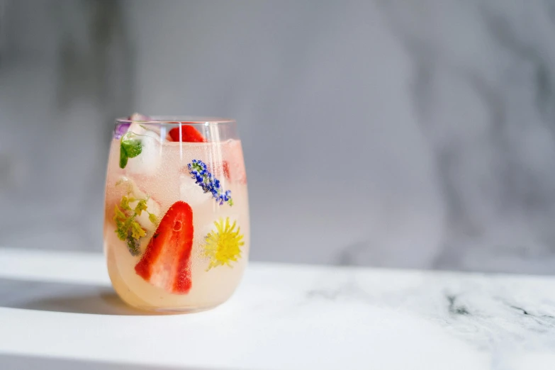 a close up of a drink in a glass on a table, made of flowers and berries, profile image, lemonade, dezeen