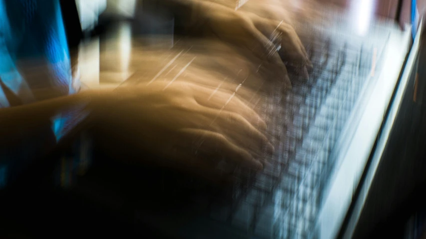 a blurry photo of a person typing on a laptop, inspired by Andreas Gursky, unsplash, lyrical abstraction, detailed mechanical hands, thumbnail, long exposure 8 k, pianist