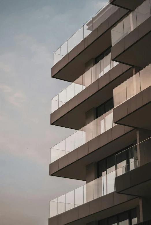a tall building with balconies and glass balconies, pexels contest winner, modernism, paul barson, unsplash 4k, ignant, soft morning lighting