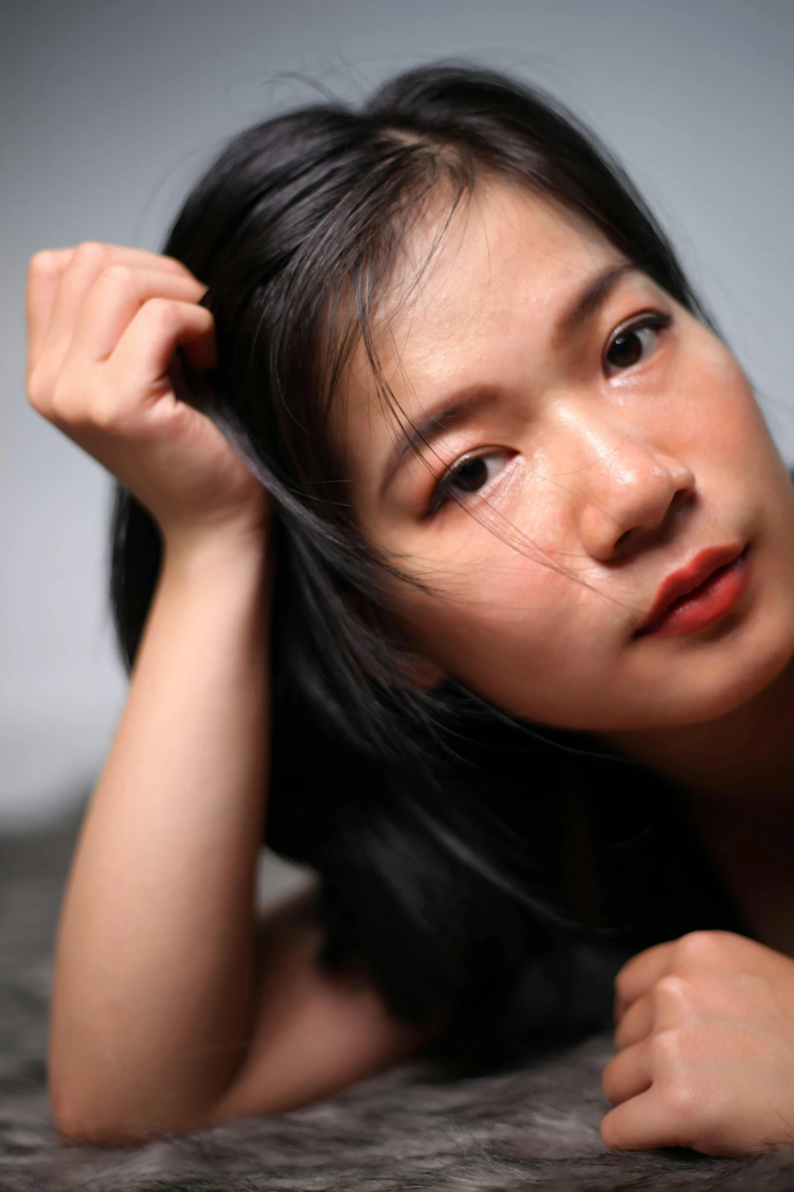 a beautiful young woman laying on top of a bed, reddit, hyperrealism, south east asian with round face, scratches on photo, trending photo, close up portrait photo