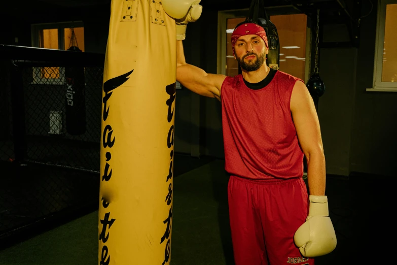 a man standing next to a punching bag, profile image, johnny silverhand, sports clothing, 8ft tall