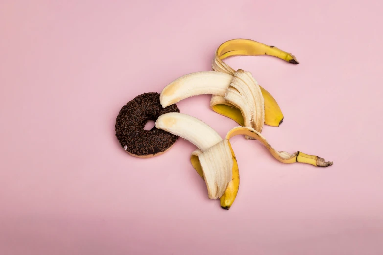 a couple of bananas sitting on top of a pink surface, by Nina Hamnett, trending on pexels, bagels, chewing tobacco, yin yang, on clear background